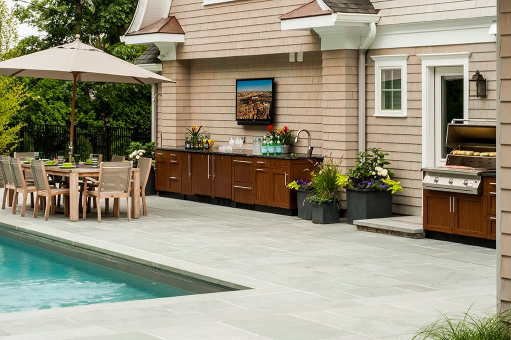 Outdoor kitchen with dining area poolside